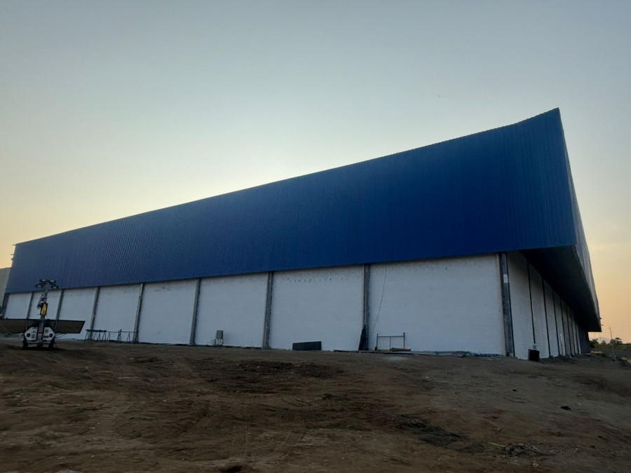 Silhueta de galpão industrial da Engemec ao entardecer, estrutura metálica e cobertura
